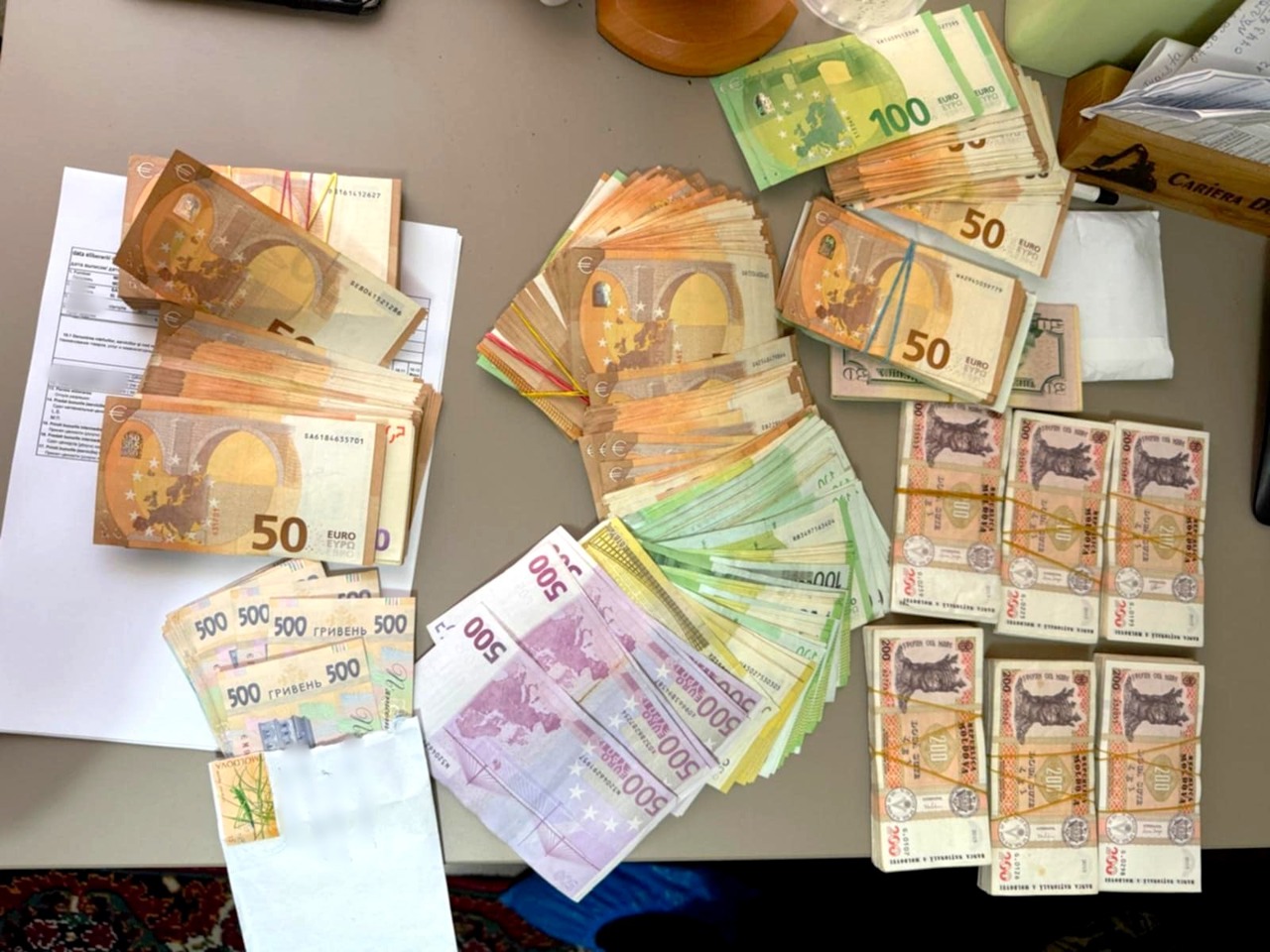 Bani furați din reparația drumurilor pentru a cumpăra apartamente peste hotare: Cinci persoane implicate într-o schemă de fraudare a bugetului public, reținute