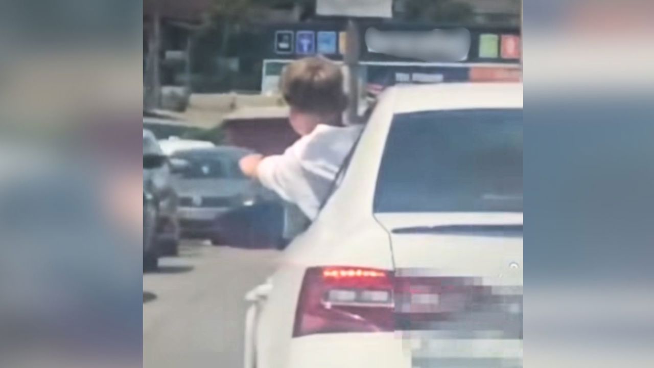 VIDEO | Copil surprins ieșind pe geamul unei mașini în trafic. Șoferul, amendat