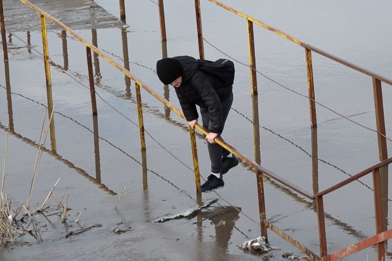 Echilibristică pe un pod inundat din Bălți. Oamenii au traversat râul Răut cățărându-se pe balustradă