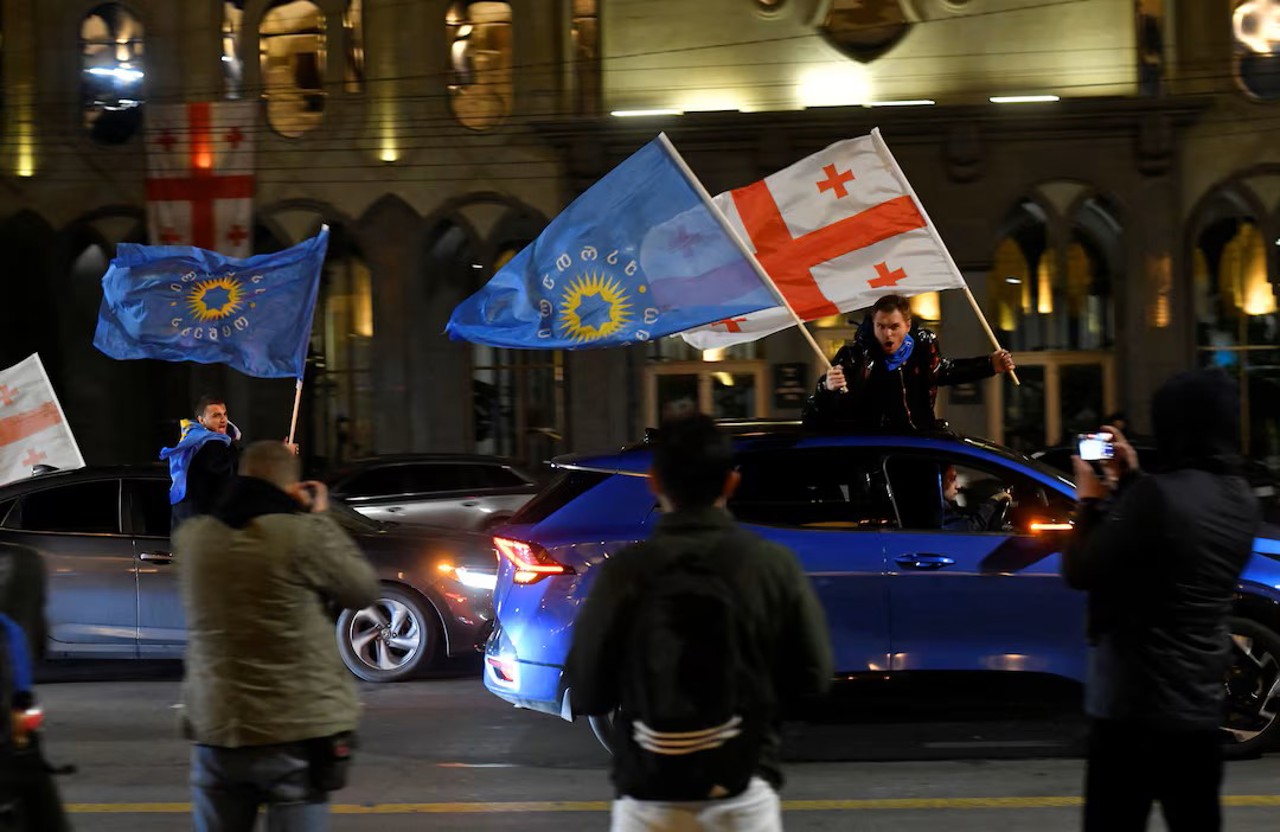 Reuters / Supporters of the Georgian Dream party wave Georgian flags and party flags from their cars after the announcement of exit poll results in parliamentary elections, in Tbilisi, Georgia, October 26, 2024.