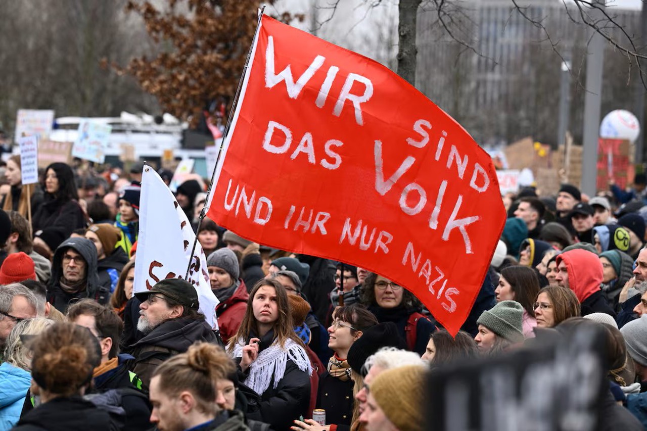 Reuters / People gather during a rally of the broad alliance "Hand in Hand" under the slogan "Wir sind die Brandmauer" ("We are the fire wall") to protest against right-wing extremism and to protect democracy, in Berlin, Germany, February 3, 2024. The text reads: "We are the people and you are just Nazis"